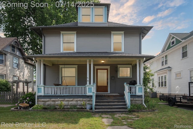 305 E 6th St, Monroe, MI 48161 - american foursquare style home with covered porch, a front lawn, and roof with shingles