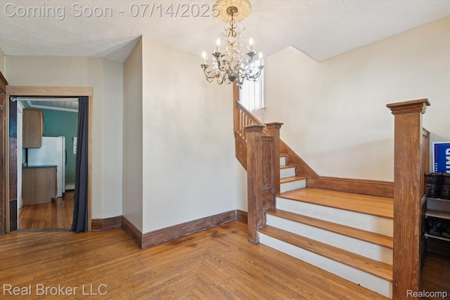 305 E 6th St, Monroe, MI 48161 - staircase featuring a chandelier, wood finished floors, and a textured ceiling
