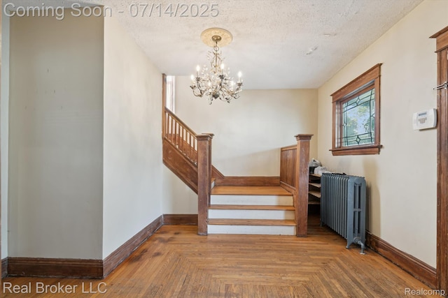 305 E 6th St, Monroe, MI 48161 - staircase featuring radiator heating unit, a chandelier, and a textured ceiling