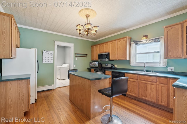 305 E 6th St, Monroe, MI 48161 - kitchen featuring stainless steel appliances, washing machine and dryer, a kitchen island, light wood-type flooring, and ornamental molding