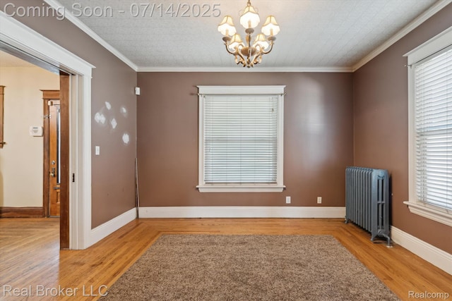 305 E 6th St, Monroe, MI 48161 - unfurnished room with radiator heating unit, a chandelier, wood finished floors, and ornamental molding