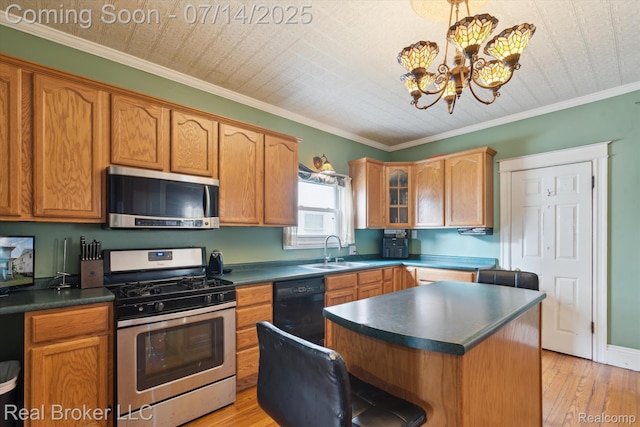 305 E 6th St, Monroe, MI 48161 - kitchen featuring appliances with stainless steel finishes, dark countertops, light wood-type flooring, a chandelier, and a center island