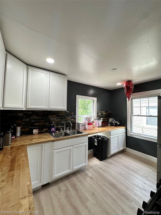 20245 Archdale St, Detroit, MI 48235 - kitchen with light wood-type flooring, tasteful backsplash, white cabinets, wooden counters, and recessed lighting