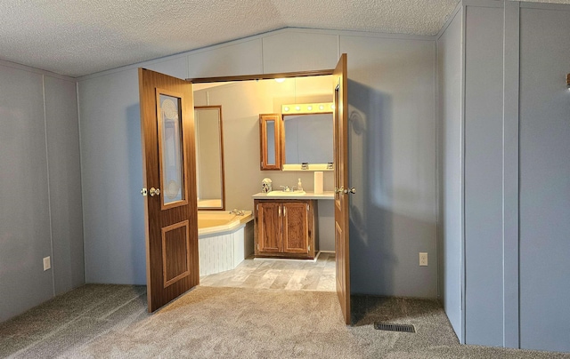 5955 N Pendell Rd, Elwell, MI 48832 - full bath with vaulted ceiling, vanity, a garden tub, a textured ceiling, and carpet flooring