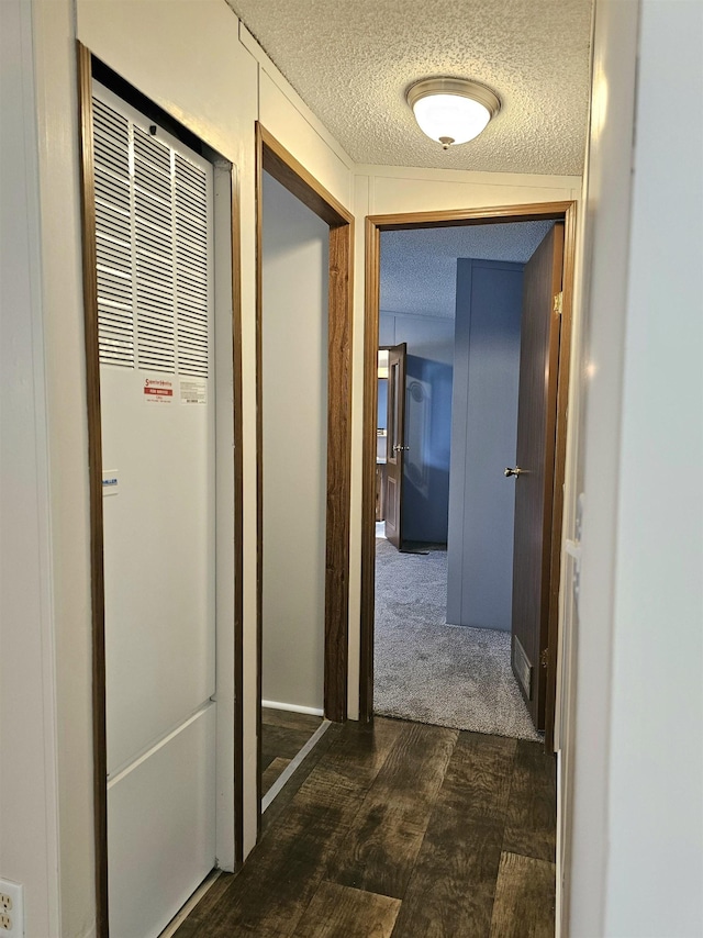 5955 N Pendell Rd, Elwell, MI 48832 - hallway featuring a heating unit, a textured ceiling, and dark wood finished floors
