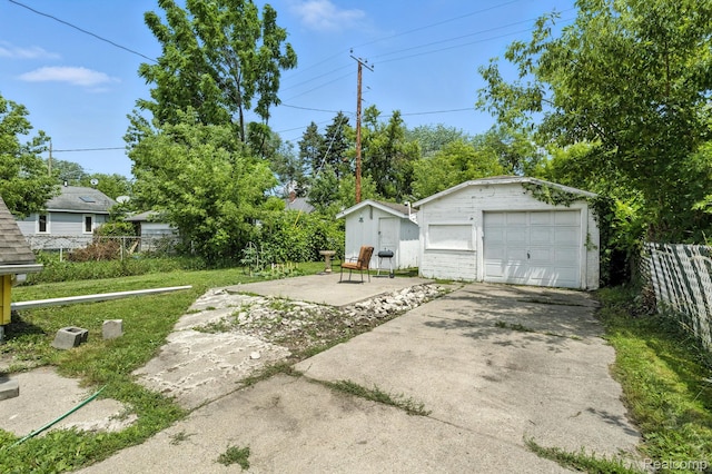2424 10th Ave, Port Huron, MI 48060 - view of yard featuring an outdoor structure, a detached garage, and concrete driveway