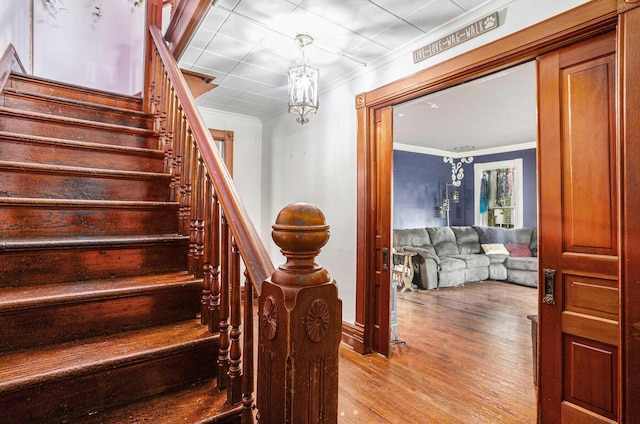 429 Portage Ave, Three Rivers, MI 49093 - stairway featuring wood finished floors, ornamental molding, and a chandelier