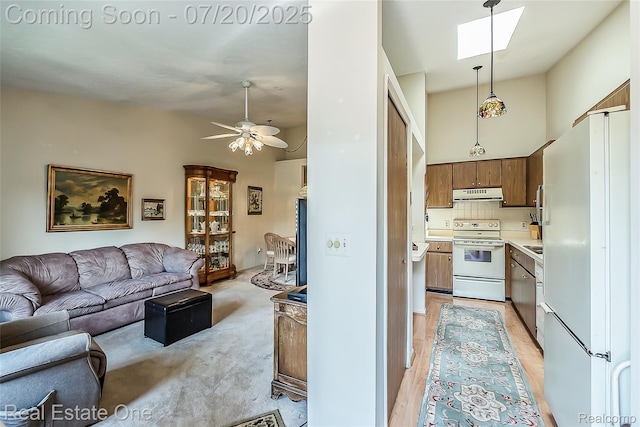 25104 Hamilton Ct Unit 4, South Lyon, MI 48178 - kitchen with white appliances, open floor plan, under cabinet range hood, brown cabinets, and light countertops