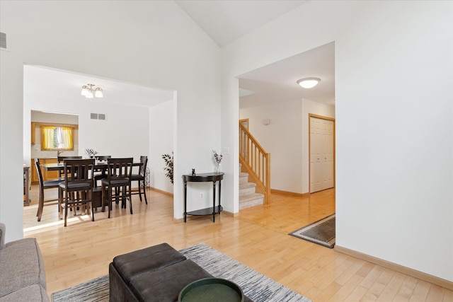 2388 Chestnut Cres, Saline, MI 48176 - living room with stairs, wood finished floors, and high vaulted ceiling