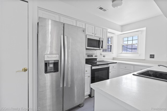 6614 Embers Ct, West Bloomfield, MI 48322 - kitchen with appliances with stainless steel finishes, white cabinetry, light countertops, and light wood-style floors