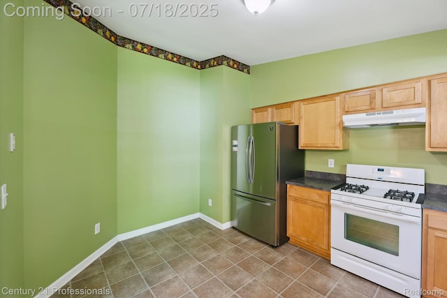 1605 N Hanlon St, Westland, MI 48185 - kitchen with white range with gas stovetop, under cabinet range hood, freestanding refrigerator, and dark countertops