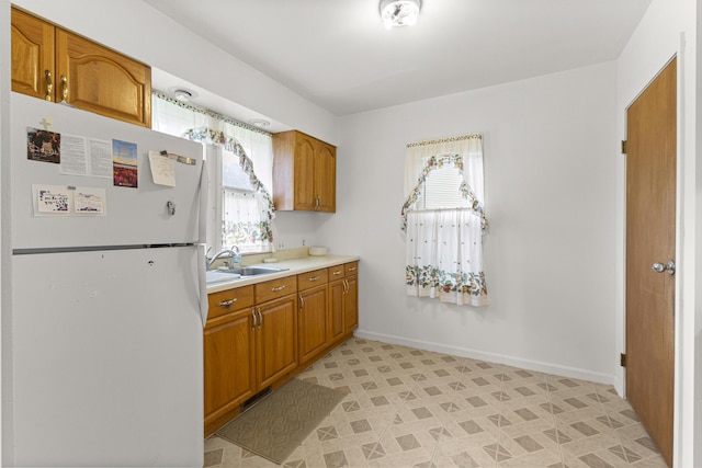 622 Tromley St, Inkster, MI 48141 - kitchen featuring freestanding refrigerator, light countertops, and brown cabinets