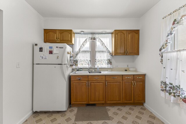 622 Tromley St, Inkster, MI 48141 - kitchen with freestanding refrigerator, brown cabinetry, and healthy amount of natural light