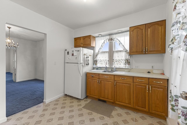 622 Tromley St, Inkster, MI 48141 - kitchen featuring freestanding refrigerator, brown cabinets, light colored carpet, light countertops, and a chandelier