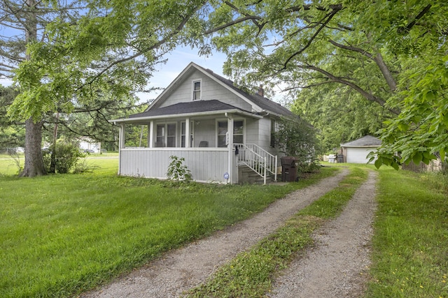 622 Tromley St, Inkster, MI 48141 - bungalow featuring a front lawn, dirt driveway, a detached garage, an outbuilding, and roof with shingles