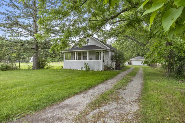622 Tromley St, Inkster, MI 48141 - bungalow-style home with a porch, an outdoor structure, a detached garage, driveway, and a shingled roof