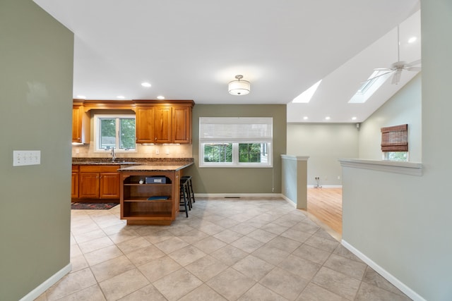 2113 Ridgeway Rd, Jackson, MI 49203 - kitchen featuring open shelves, backsplash, a skylight, light tile patterned flooring, and recessed lighting