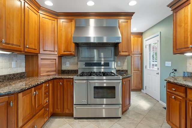 2113 Ridgeway Rd, Jackson, MI 49203 - kitchen with wall chimney range hood, gas range, brown cabinets, backsplash, and recessed lighting