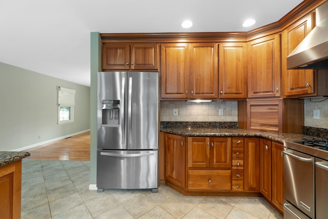 2113 Ridgeway Rd, Jackson, MI 49203 - kitchen featuring stainless steel fridge, wall chimney exhaust hood, range, brown cabinetry, and recessed lighting
