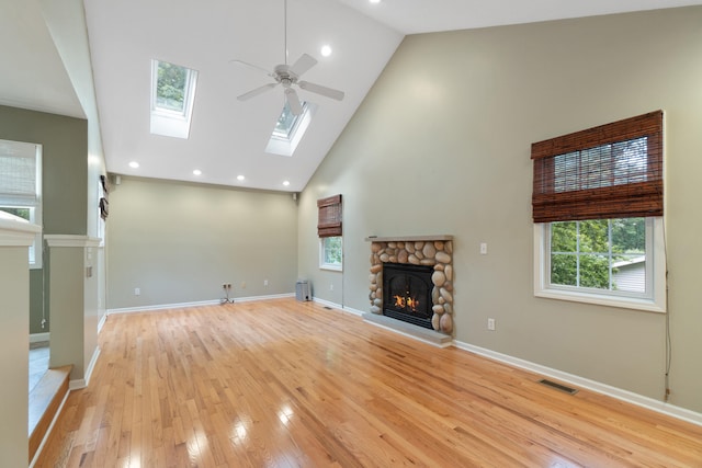 2113 Ridgeway Rd, Jackson, MI 49203 - unfurnished living room featuring a fireplace, ceiling fan, high vaulted ceiling, light wood-type flooring, and plenty of natural light