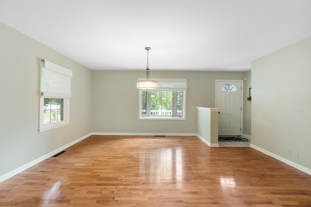 2113 Ridgeway Rd, Jackson, MI 49203 - unfurnished dining area with light wood-type flooring and baseboards