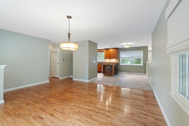 2113 Ridgeway Rd, Jackson, MI 49203 - unfurnished living room with light wood-type flooring and baseboards