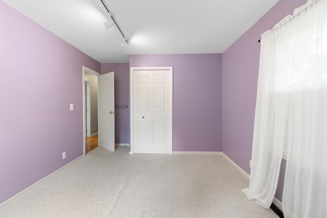 2113 Ridgeway Rd, Jackson, MI 49203 - unfurnished bedroom featuring carpet floors, rail lighting, and a closet