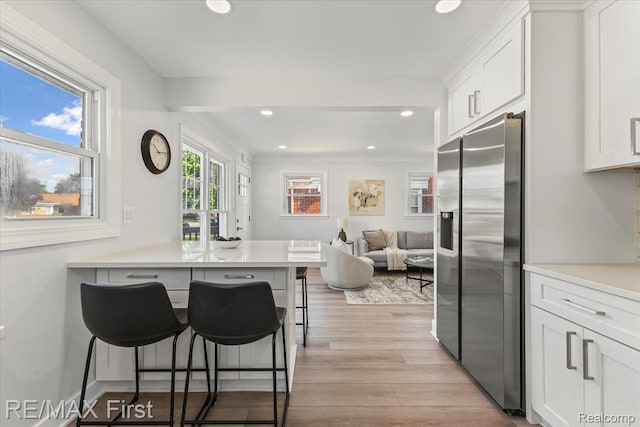 29924 Taylor St, Saint Clair Shores, MI 48082 - kitchen with stainless steel fridge, a breakfast bar area, white cabinetry, recessed lighting, and light wood-style floors