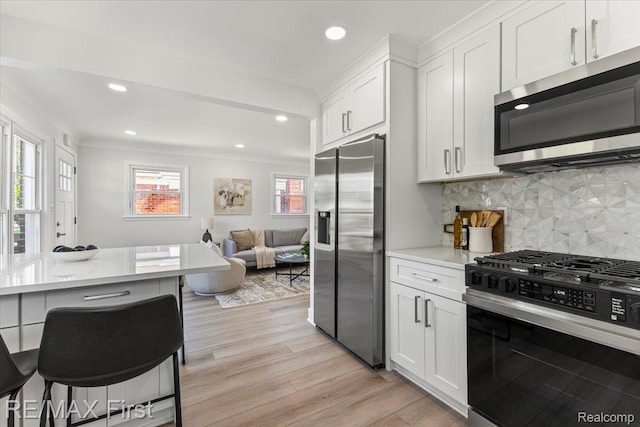 29924 Taylor St, Saint Clair Shores, MI 48082 - kitchen with appliances with stainless steel finishes, light countertops, recessed lighting, light wood-type flooring, and white cabinets