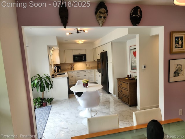 19370 W 11 Mile Rd, Lathrup Village, MI 48076 - kitchen with black appliances, light marble finish flooring, light countertops, and white cabinetry