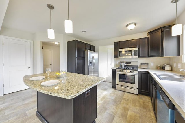 LOT107 Butternut Dr, Wayland, MI 49348 - kitchen featuring stainless steel appliances, dark brown cabinetry, light wood-style floors, light stone counters, and pendant lighting