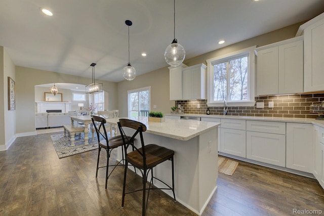 MOH45 Birkdale Dr Unit 45, Howell, MI 48843 - kitchen with tasteful backsplash, white cabinetry, a kitchen bar, dark wood finished floors, and a center island