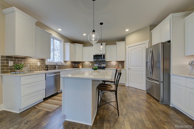 MOH45 Birkdale Dr Unit 45, Howell, MI 48843 - kitchen featuring stainless steel appliances, dark wood-style floors, a kitchen island, white cabinetry, and recessed lighting