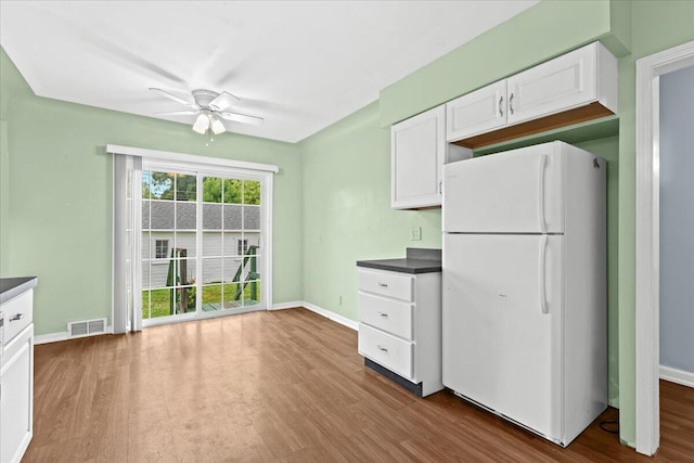 21197 Nummer St, Warren, MI 48089 - kitchen with freestanding refrigerator, ceiling fan, dark countertops, white cabinetry, and wood finished floors