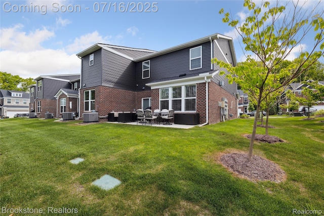 765 Hummingbird Dr, Rochester Hills, MI 48307 - rear view of house featuring brick siding, a patio area, and a lawn