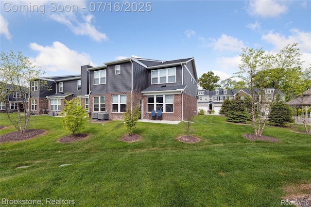 765 Hummingbird Dr, Rochester Hills, MI 48307 - rear view of property featuring brick siding, a patio area, and a yard