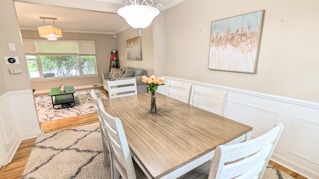 20519 Mauer St, Saint Clair Shores, MI 48080 - dining area with ornamental molding, wood finished floors, a decorative wall, and wainscoting