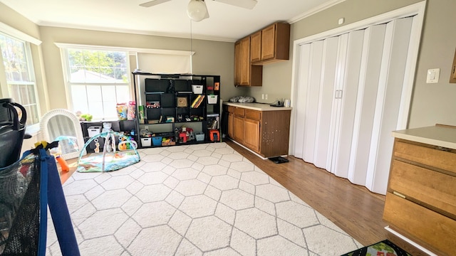 20519 Mauer St, Saint Clair Shores, MI 48080 - kitchen featuring brown cabinetry, ornamental molding, light wood-style flooring, ceiling fan, and light countertops