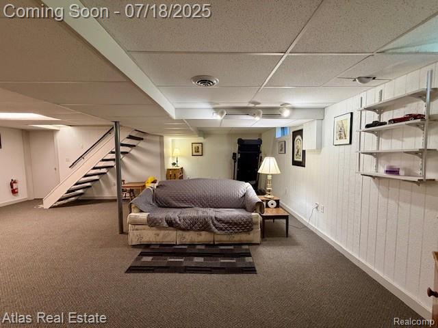 8354 Ridge Rd, Goodrich, MI 48438 - carpeted living area featuring stairway and a paneled ceiling