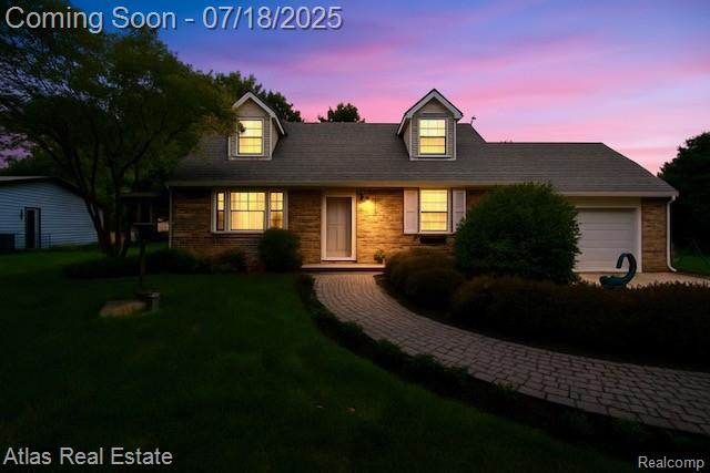 8354 Ridge Rd, Goodrich, MI 48438 - cape cod house featuring a garage, a yard, and driveway