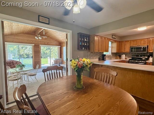 8354 Ridge Rd, Goodrich, MI 48438 - dining room with a ceiling fan, lofted ceiling, and wood walls