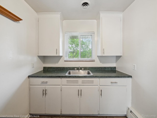 1010 Laprairie St, Ferndale, MI 48220 - kitchen featuring dark countertops, white cabinets, and a baseboard heating unit