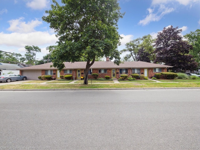 1010 Laprairie St, Ferndale, MI 48220 - ranch-style home with brick siding, an attached garage, concrete driveway, a chimney, and a front lawn