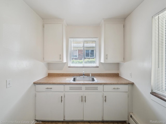 1010 Laprairie St, Ferndale, MI 48220 - kitchen featuring white cabinetry, light countertops, and a baseboard radiator