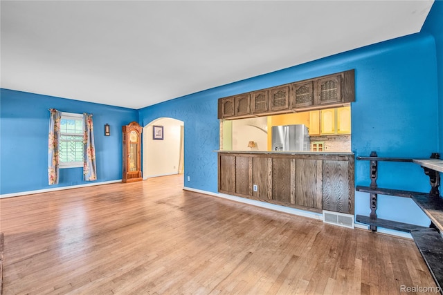 3870 Benstein Rd, Commerce Twp, MI 48382 - spare room featuring arched walkways and wood finished floors