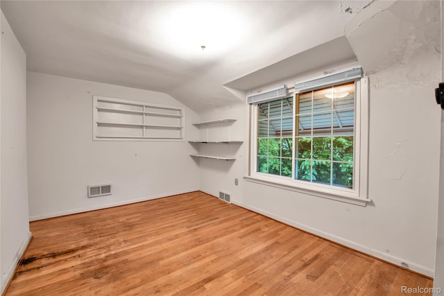 3870 Benstein Rd, Commerce Twp, MI 48382 - spare room featuring wood finished floors and vaulted ceiling