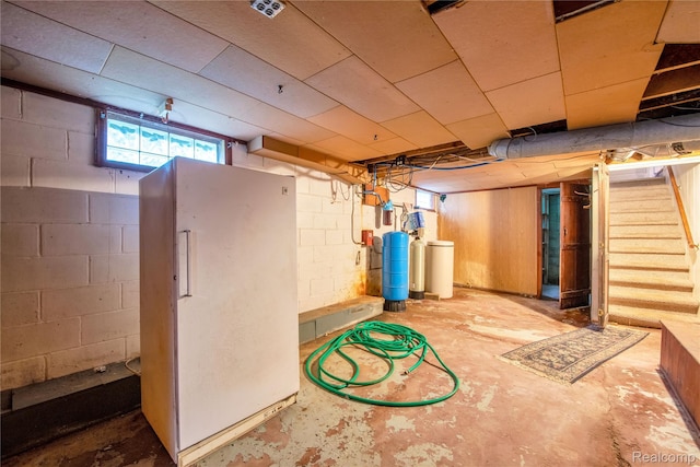 3870 Benstein Rd, Commerce Twp, MI 48382 - below grade area with a water softener, stairs, freestanding refrigerator, and a water pressure tank