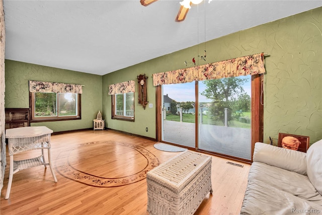 3870 Benstein Rd, Commerce Twp, MI 48382 - living room with wood finished floors, a textured wall, and a ceiling fan