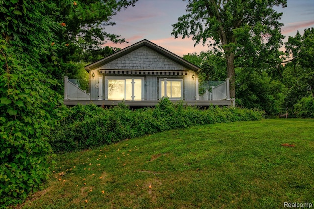 3870 Benstein Rd, Commerce Twp, MI 48382 - back of house at dusk with a deck and a yard