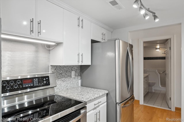 3559 Port Cove Dr Unit 17, Waterford, MI 48328 - kitchen featuring appliances with stainless steel finishes, white cabinets, decorative backsplash, light wood-style floors, and light stone counters